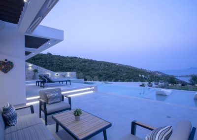 Luxury villa pool deck with loungers overlooking the Ionian horizon