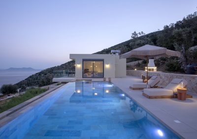 Elevated infinity pool terrace at Nikiana villa with panoramic coastline views