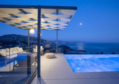 Elevated infinity pool terrace at Nikiana villa with panoramic coastline views