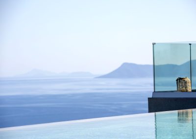 Elevated infinity pool terrace at Nikiana villa with panoramic coastline views