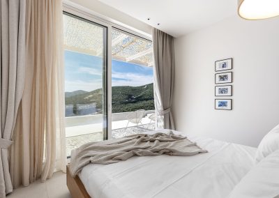 Modern ensuite bedroom at Villa Mia Rose designed for comfort with natural light and scenic sea views